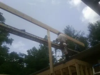 Carpenter setting a ridge beam over a new addition frame — Ice Dam Removal by Roofing Brothers in Munroe Falls