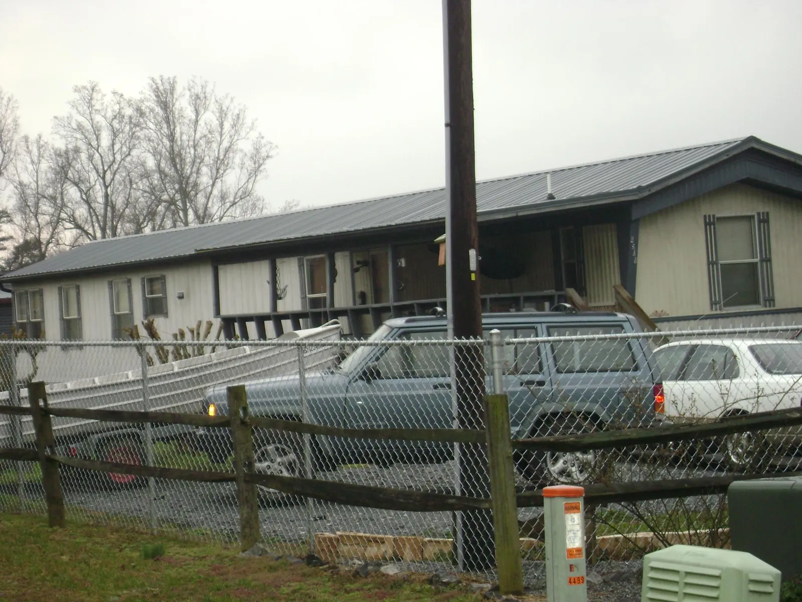 Dark metal roof on a long single story building behind a chain link fence in Munroe Falls