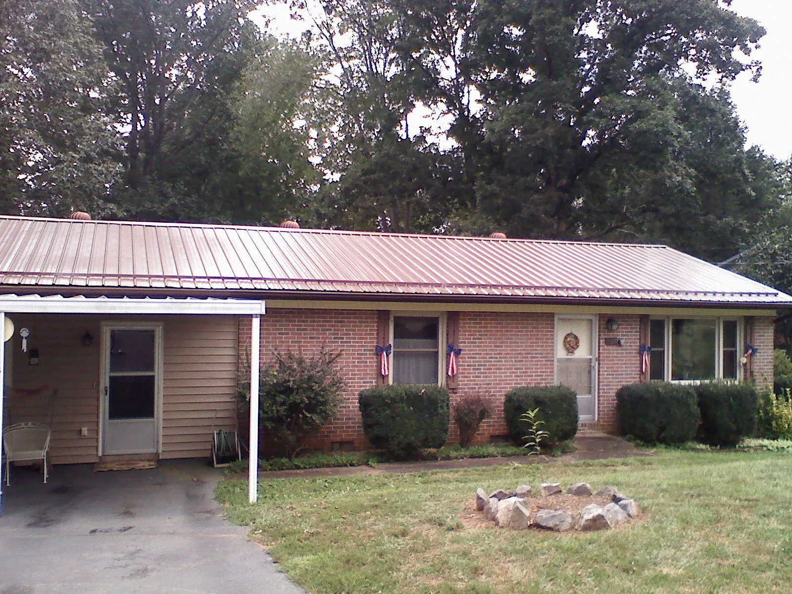 Bronze metal roof and carport on a brick ranch home — Roof Repair work by our crew in Munroe Falls